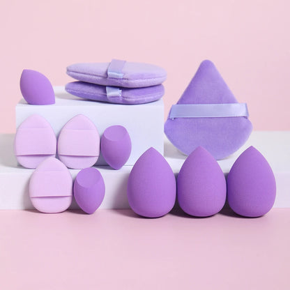 Set of purple makeup sponges and a cone-shaped item on a pink background